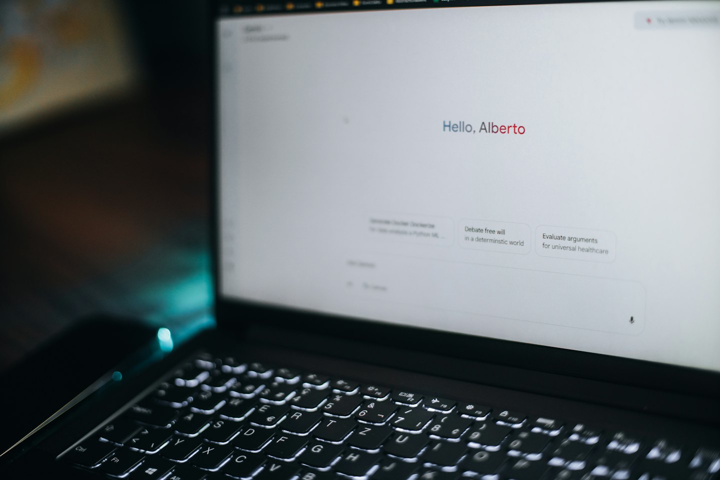 L'écran d'un ordinateur portable affiche une interface d'IA avec une salutation et des invites.